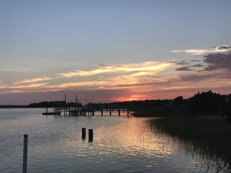 A beautiful sunset at a dock in Myrtle Beach, capturing the reflection on calm waters.